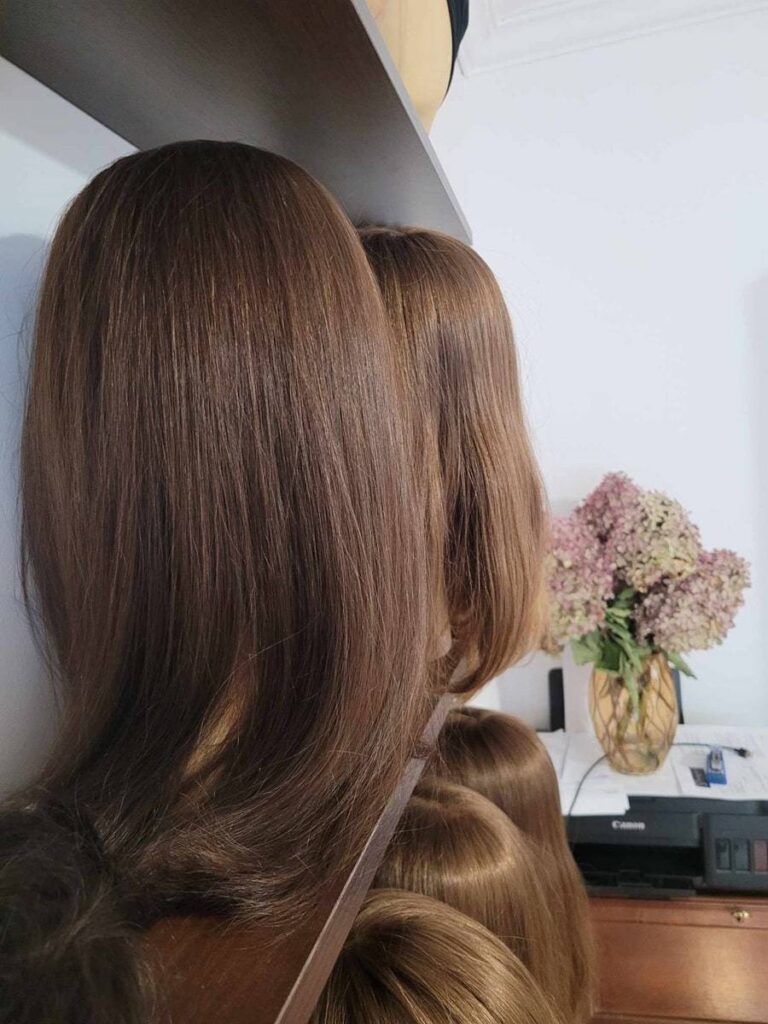 Peruki z włosów naturalnych przechowywane na stojakach